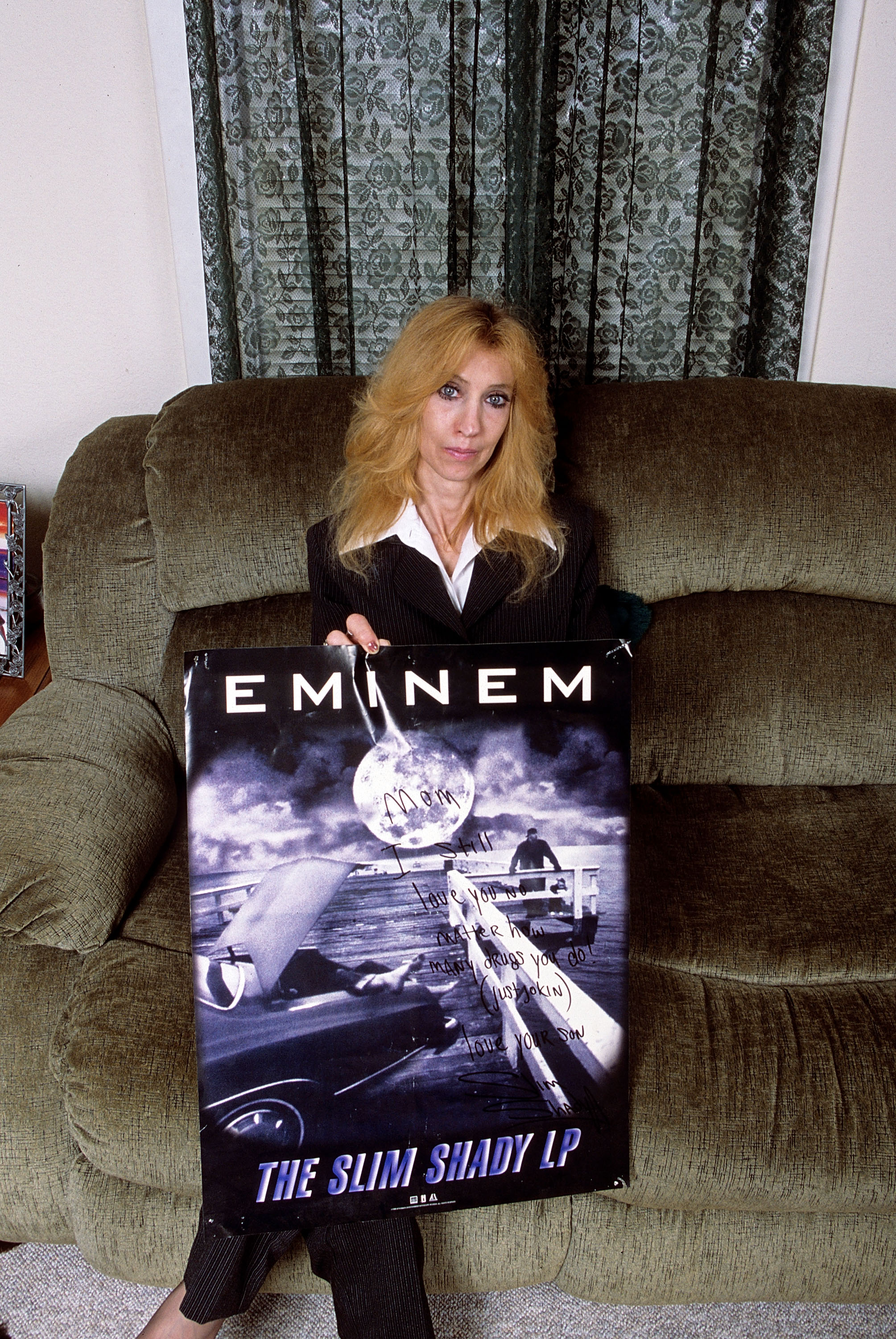 Eminem's mother Debbie Mathers holds a poster with a hand written message during a portrait session at her home in September 2005 in Detroit, Michigan