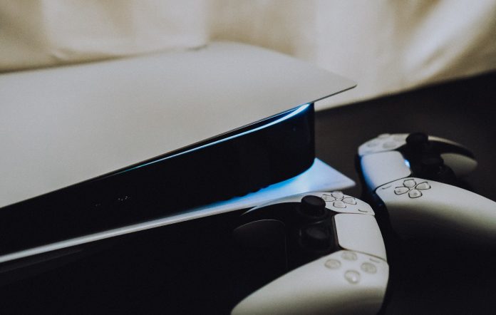 A PS5 and two DualSense controllers